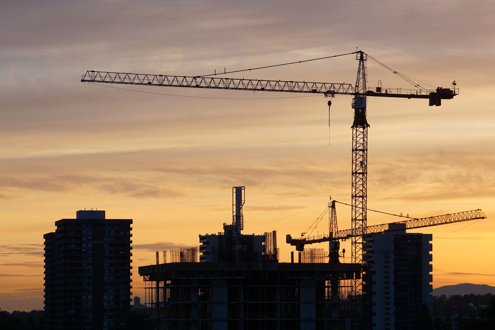 A construction site silhouetted at sunset